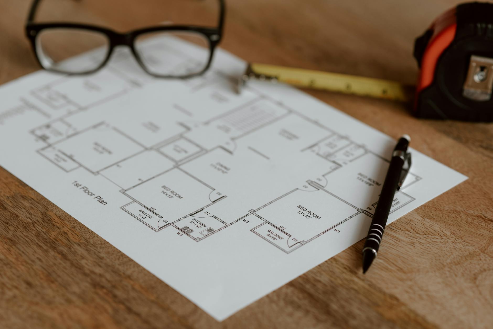 pen with ruler and eyeglasses placed on house plan